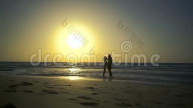浪漫的夫妻<strong>正在</strong>水中的海滩上坠入爱河。 男人和女人牵着手走<strong>在</strong>金色的道<strong>路上</strong>